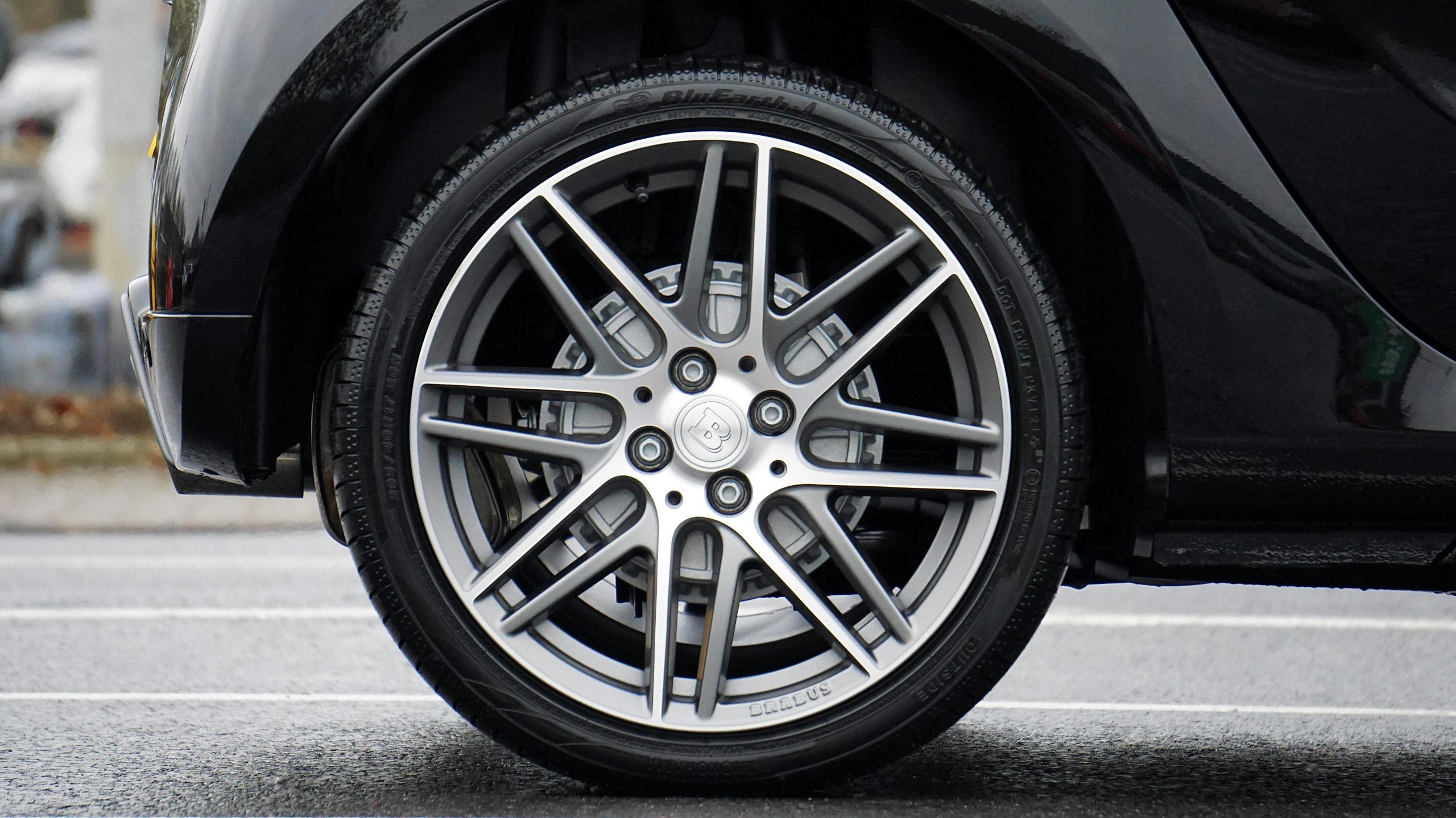 Home Detailed shot of a sleek car wheel and rim on a black vehicle, showcasing automotive design.